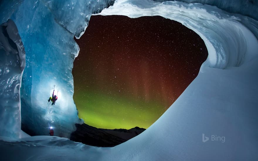 Climbing Athabasca Glacier in Jasper National Park, Alberta, Canada, as the aurora borealis glows