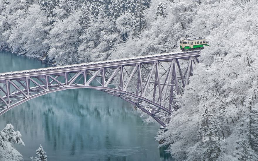 Train crossing the Tadami River near Mishima village in Japan